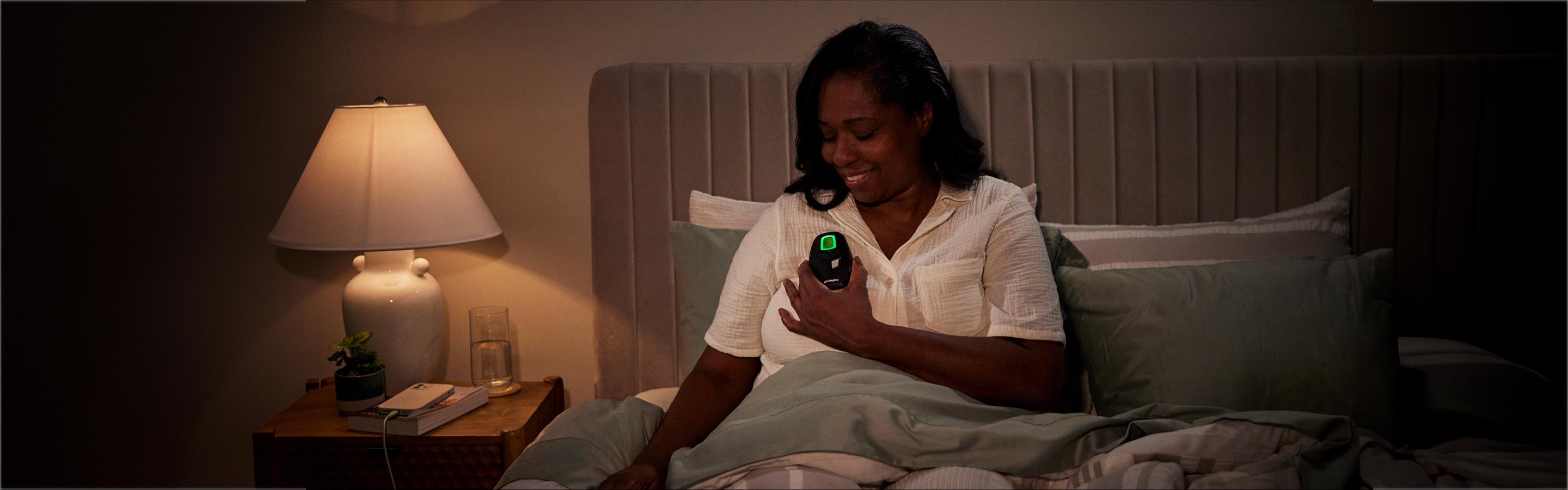 Woman using an inspire therapy remote before bedtime