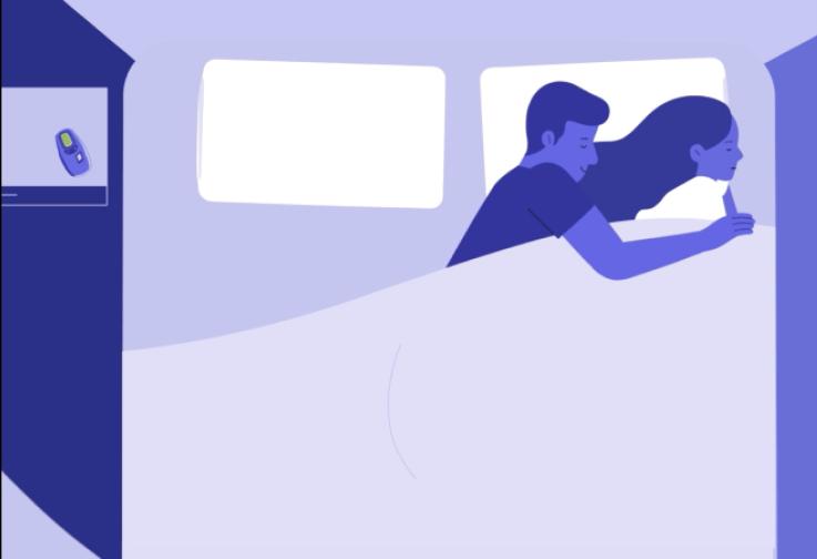 The image depicts two people, likely a couple, in a bed with a white duvet. 